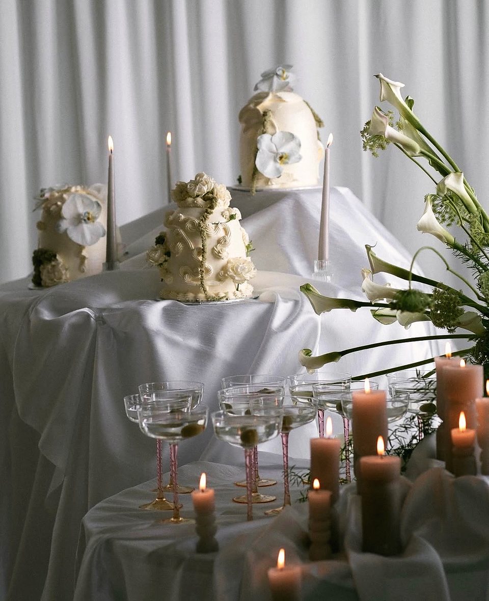 Event cake table with candles, coupes and calla lilies
